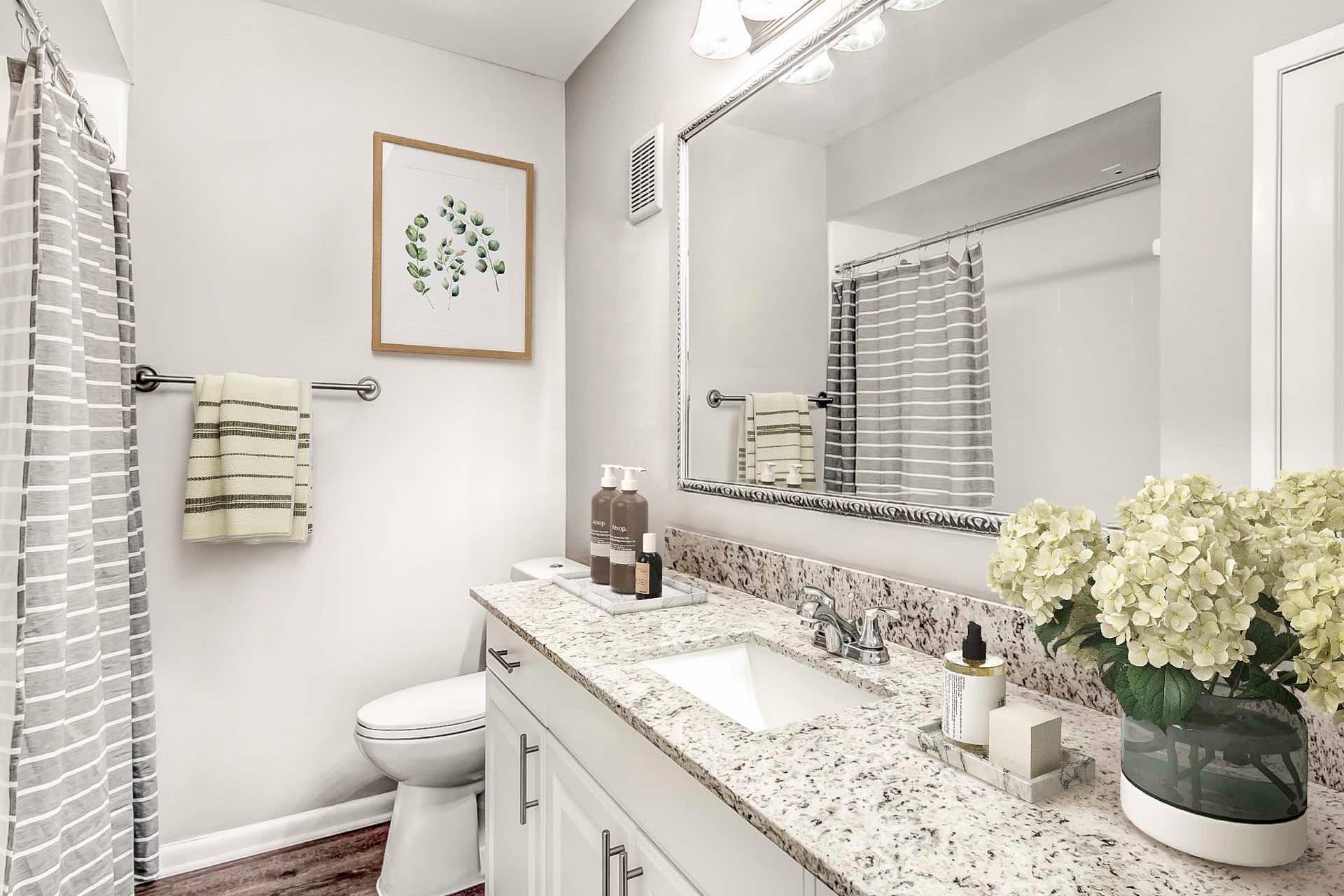 bathroom with wood-style flooring and large counter surface and ample lighting