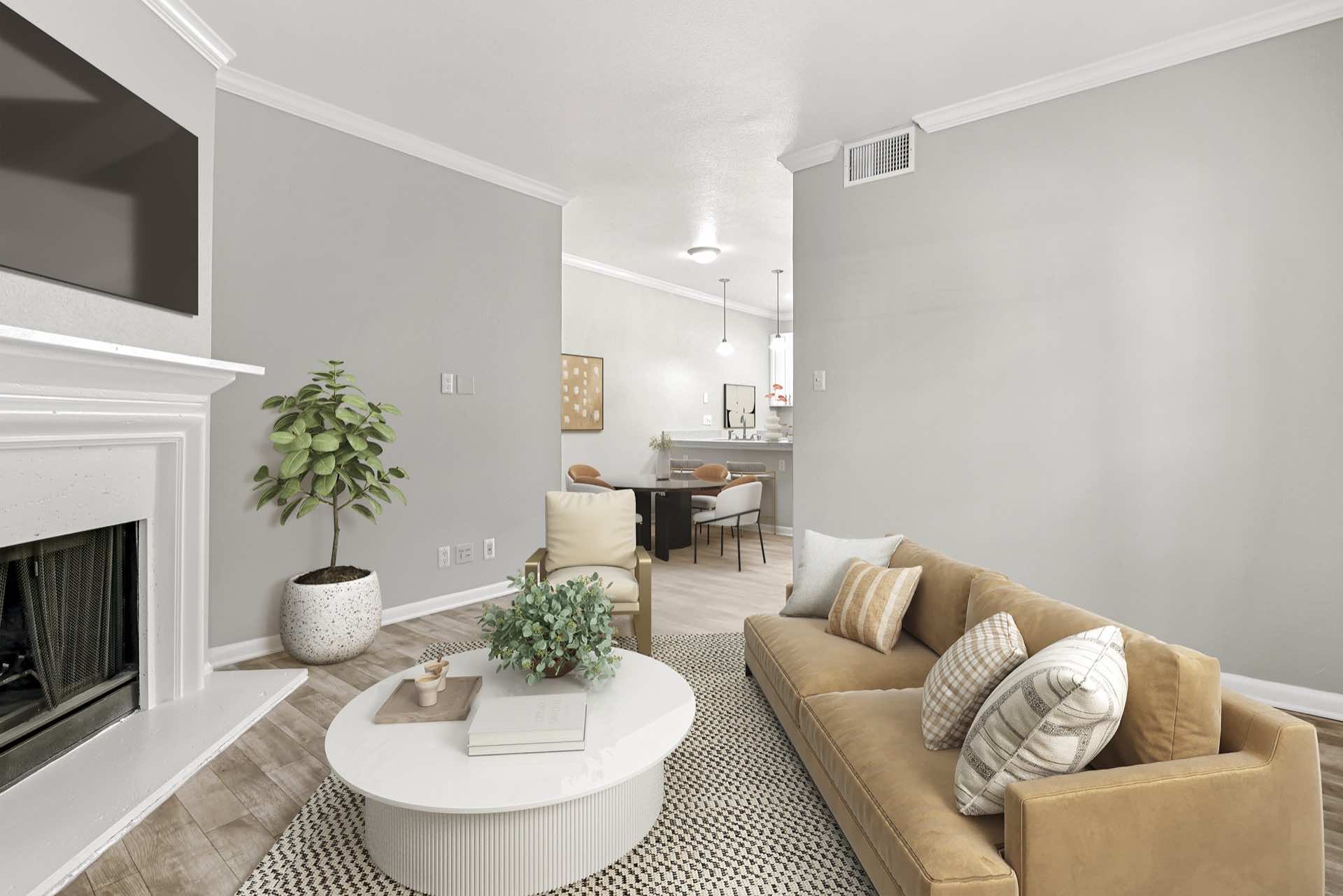 living room with brown couch, small white table, and fireplace and dining room in background