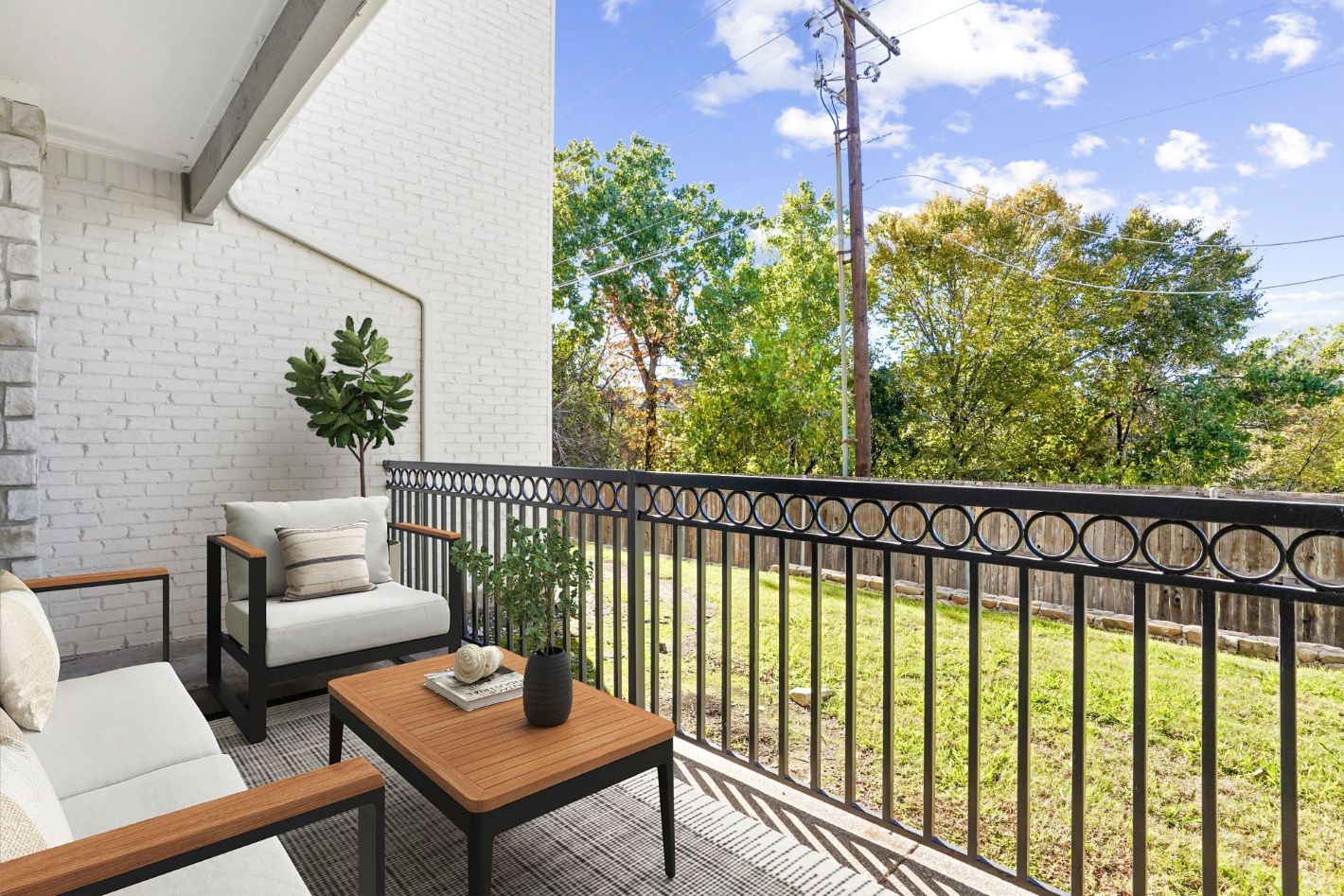 Charming patio with stylish seating, lush greenery, and scenic views of vibrant trees under a clear blue sky.
